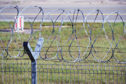 Barbed wire separating the airport runway from the rest of the area. photo