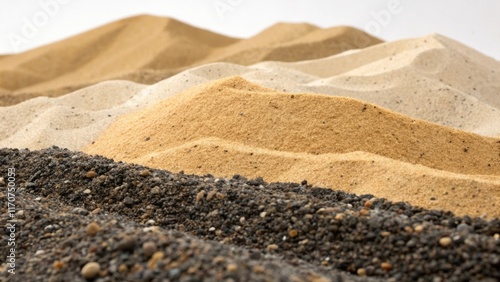 A layered view of sand and gravel showcases different stratifications where lighter sands rise to the top sitting atop darker cor gravels underneath. The play of light creates an photo