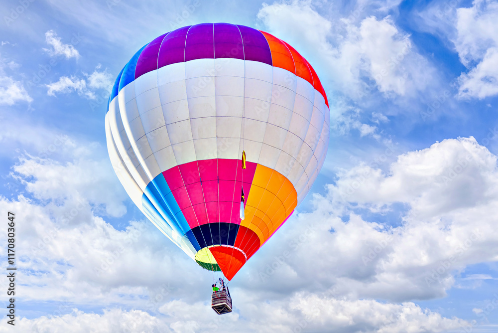 Naklejka premium Colorful hot air balloon flying over blue sky with white clouds