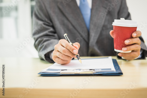 Male lawyer diligently examines documents placed on his desk, demonstrating his professionalism and dedication to finding legal truth, analyzing ideas, and pursuing justice with relentless focus. photo