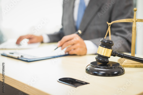 Male lawyer diligently examines documents placed on his desk, demonstrating his professionalism and dedication to finding legal truth, analyzing ideas, and pursuing justice with relentless focus.