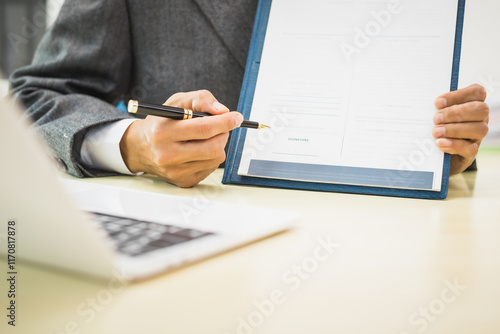 Male lawyer diligently examines documents placed on his desk, demonstrating his professionalism and dedication to finding legal truth, analyzing ideas, and pursuing justice with relentless focus. photo