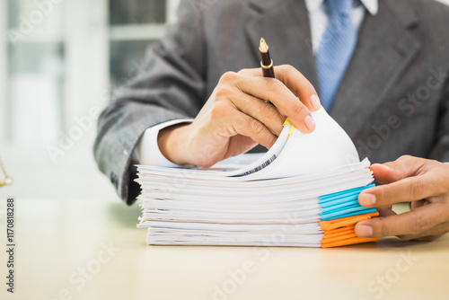 Male lawyer diligently examines documents placed on his desk, demonstrating his professionalism and dedication to finding legal truth, analyzing ideas, and pursuing justice with relentless focus.