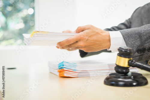 Male lawyer diligently examines documents placed on his desk, demonstrating his professionalism and dedication to finding legal truth, analyzing ideas, and pursuing justice with relentless focus. photo