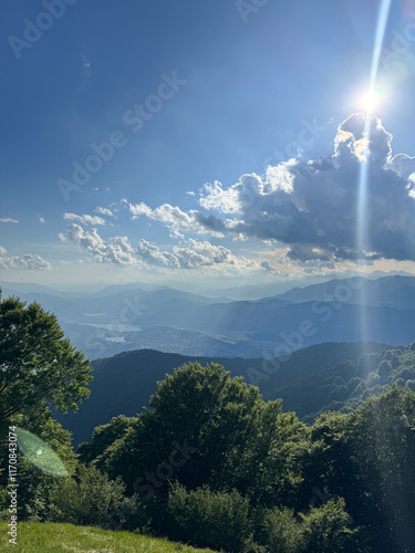 Arial view or Lugano from a mountaintop wit mountain layers in the background and sun shining with sun rays though the clouds from Monte Boglia in Switzerland photo