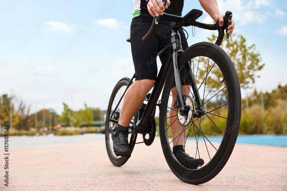 Naklejka premium Athletic man with bicycle outdoors, closeup. Space for text