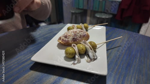 close-up view of traditional Spainsh tapas in a bar shared by two friend chatting and drinking homemade vermouth. 4K