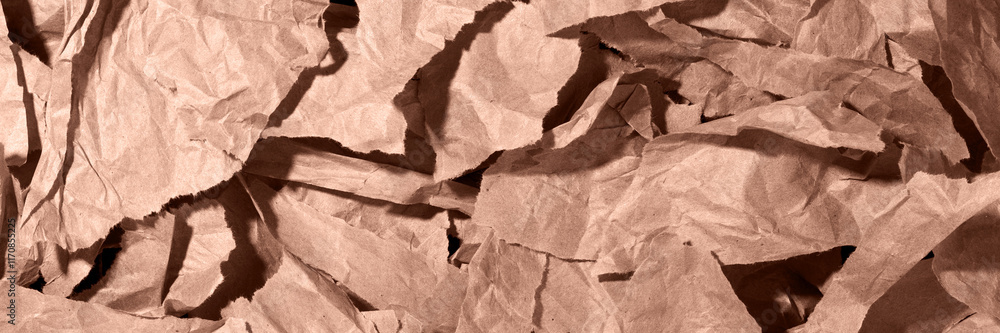 Fototapeta premium Multiple pieces of torn brown, mocha mousse crumpled, wrinkled recycle craft paper background texture, top view banner.