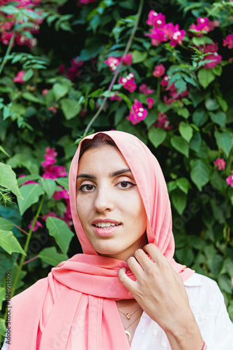 Fotografía Portrait of a young and beautiful Muslim woman with a floral garden background