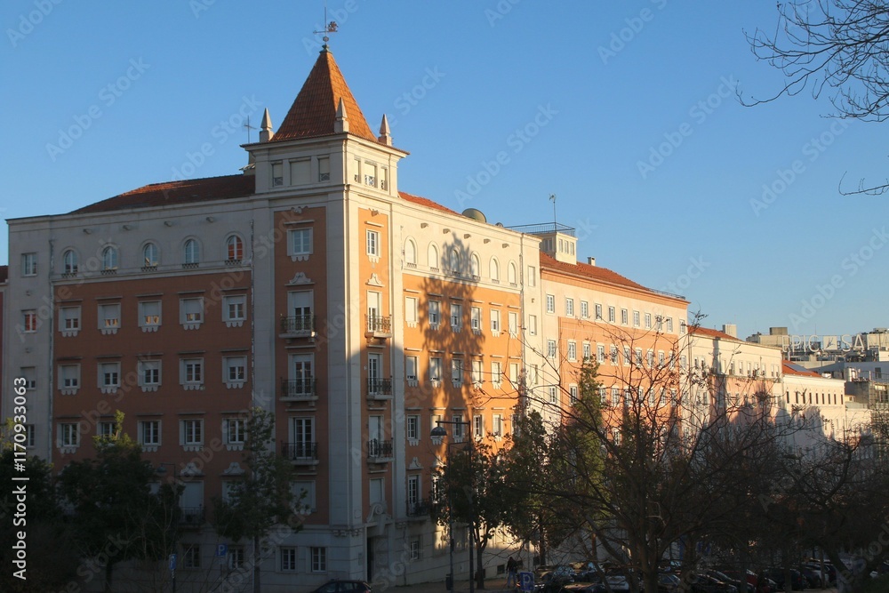 Naklejka premium Historic building in Lisbon with a clear sky, showing classic architecture and warm sunlight.