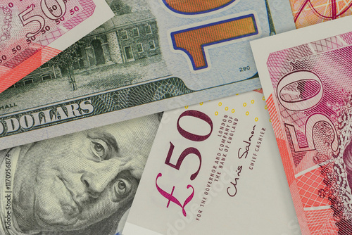 Portrait of the US President on the dollar bill peeks out from underneath the British pound notes. Currency market. Finance concept