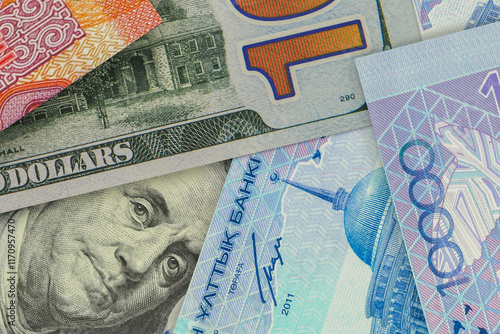 US $100 bill peeking out from under Kazakhstani tenge bills. Foreign exchange market. financial concept photo