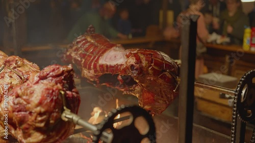 Roasted a whole big pig on fire. Grilled on a big skewer. Roasting piglet on a spit turns slowly roasting it. Barbecue. Street food. 4k. Lechon or Suckling popular dish. pigs roasting on fire pit and 