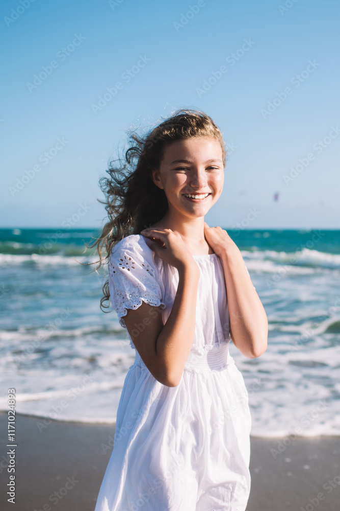 Cheerful girl in white dress standing on seashore Cheerful girl in white dress standing on seashore