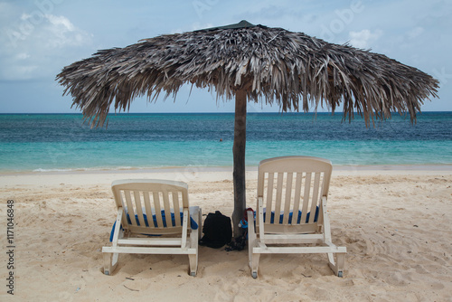 Obraz na płótnie Chairs and a Beach Umbrella and the Caribbean sea pristine waters in Guardalavaca sand beach, Club Amigo Atlantico resort hotel, Cuba w salonie