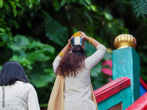 Photography Devotee carrying an offering on her head during thaipusam festival at batu caves