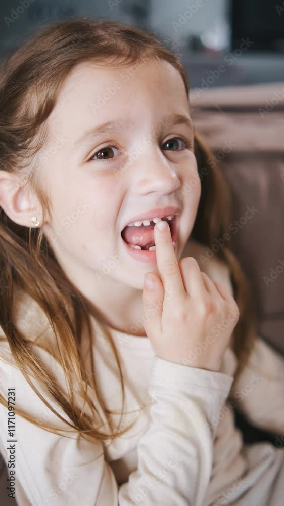 Vertical video The child shakes the front baby tooth and smiles a toothless smile close-up. Changing teeth to molars in childhood Vertical video The child shakes the front baby tooth and smiles a toothless smile close-up. Changing teeth to molars in childhood
