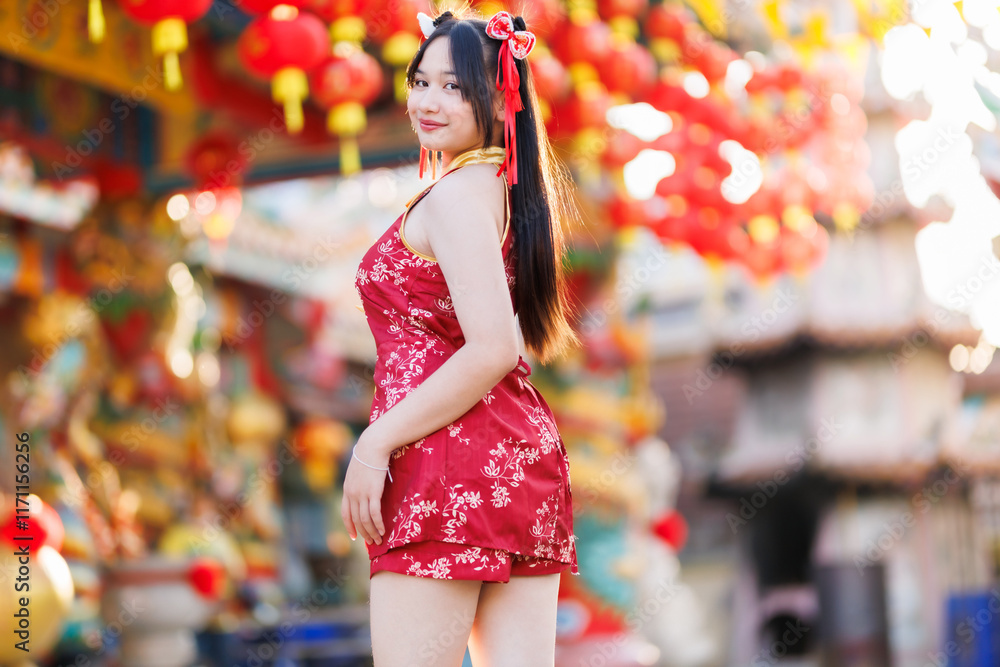 Portrait beautiful cute smiles Asian young woman wearing red cheongsam dress traditional decoration for Chinese new year festival celebrate culture of china at Chinese shrine Public places in Thailand