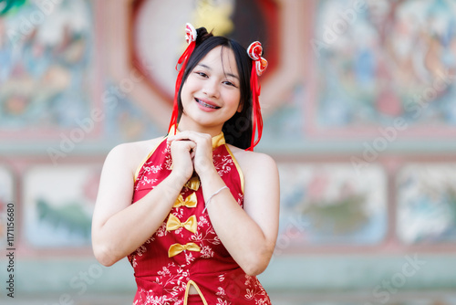 Obraz na płótnie Portrait beautiful cute smiles Asian young woman wearing red cheongsam dress traditional decoration for Chinese new year festival celebrate culture of china at Chinese shrine Public places in Thailand w salonie