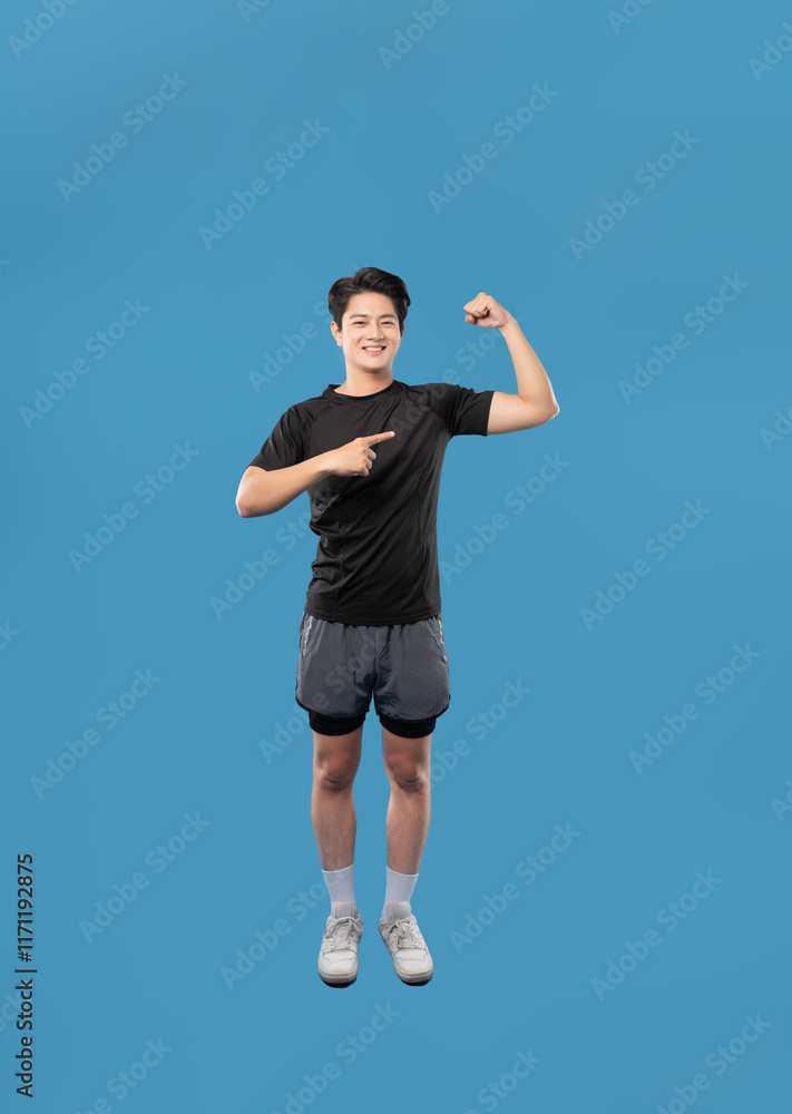 ImageFull body image of Asian guy wearing workout clothes and posing on a blue background ImageFull body image of Asian guy wearing workout clothes and posing on a blue background