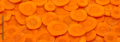 Orange horizontal background of fresh raw carrot slices photo