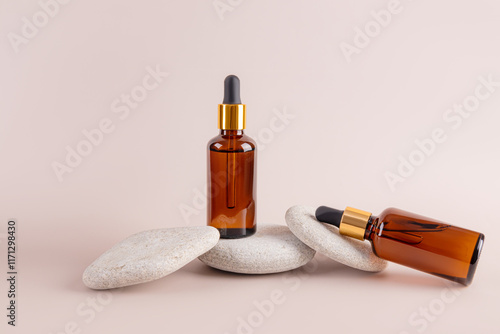 Elegant composition of amber dropper bottles on stones photo