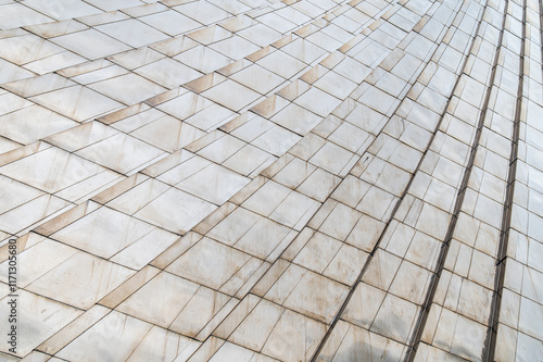 Abstract architectural surface with geometric marble tiles forming a curved pattern. The texture and design emphasize symmetry, clean lines, and modern minimalism, evoking elegance and sophistication.