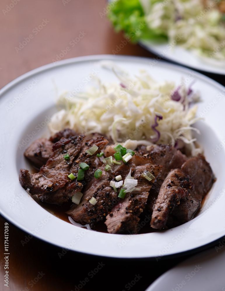 Isaan-style grilled beef, served with a side of fresh herbs and spicy Isaan-style grilled beef, served with a side of fresh herbs and spicy