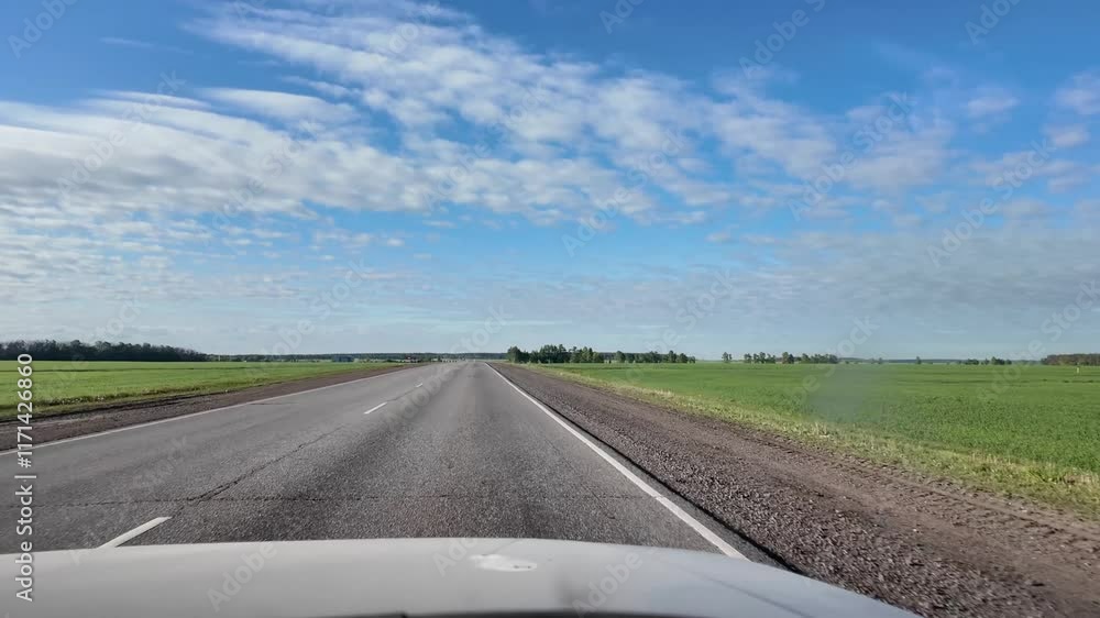 traveling by car, driving along the highway among fields and blue sky with clouds traveling by car, driving along the highway among fields and blue sky with clouds