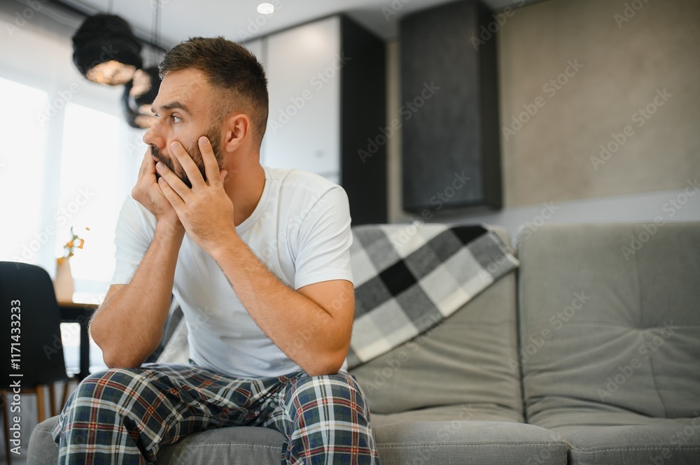 Young man suffering from strong headache or migraine, morning after hangover concept Young man suffering from strong headache or migraine, morning after hangover concept