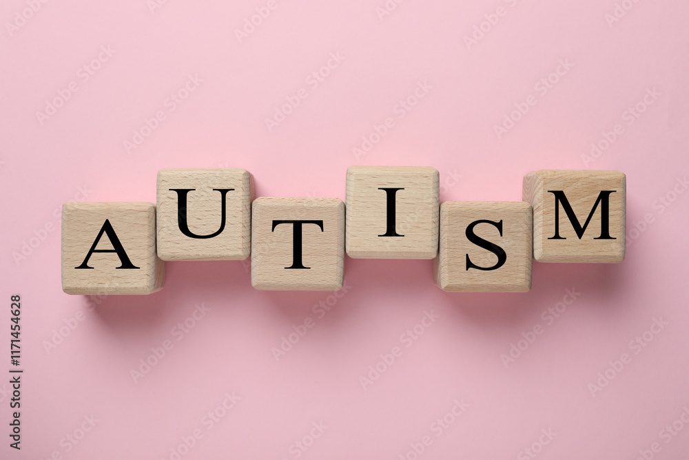 Word Autism made with wooden cubes on pink background, flat lay Word Autism made with wooden cubes on pink background, flat lay
