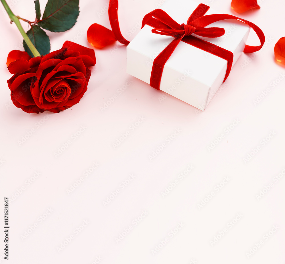 Red rose and gift box top view on soft pink empty space background. Valentine's card, romantic holiday frame. Birthday gift. Red rose and gift box top view on soft pink empty space background. Valentine's card, romantic holiday frame. Birthday gift.
