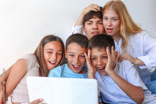 Siblings at home: triplets and elder brother and sister with laptop photo