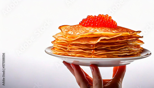 Hand with a plate of pancakes with red caviar on the top, white background photo