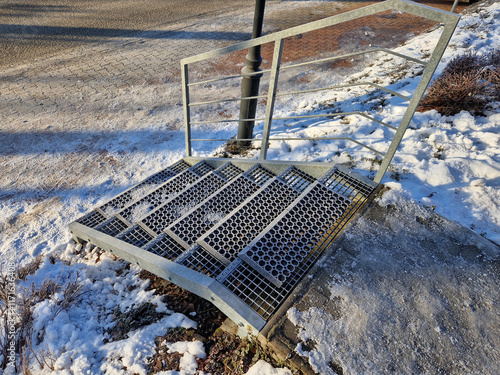 staircases made of steel gratings with rubber anti-slip mats. the mat at the cottage is on a raised staircase, snow removal from ski boots is much easier. winter surroundings of a mountain hut photo