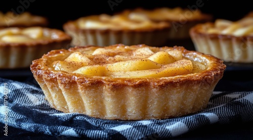 Delicious apple tart displayed on a checkered cloth in a cozy kitchen setting