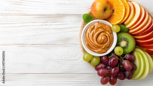 Wallpaper Mural Assorted fresh fruits including apple slices, orange slices, kiwi, grapes, and green apple, served with creamy peanut butter dip on a wooden platter over a light wooden background.

 Torontodigital.ca