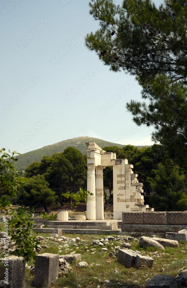 Ancient Greek ruins of the Temple of Asclepius surrounded by lush greenery and mountains Ancient Greek ruins of the Temple of Asclepius surrounded by lush greenery and mountains