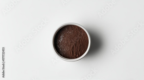 Brown cocoa powder in a white bowl on a light backdrop perfect for baking and...