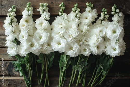 Beautiful white flowers arranged elegantly on a rustic wooden table in a cozy...