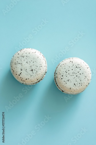 Blue macarons arranged on a pastel surface creating a visually appealing dess...