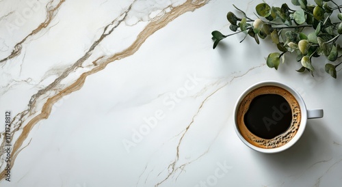 Latte art in a white cup on marble table with green leaves in the background