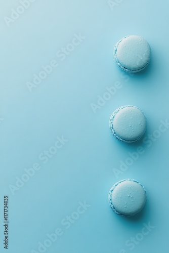 Blue macarons arranged on a pastel surface creating a visually appealing dess...