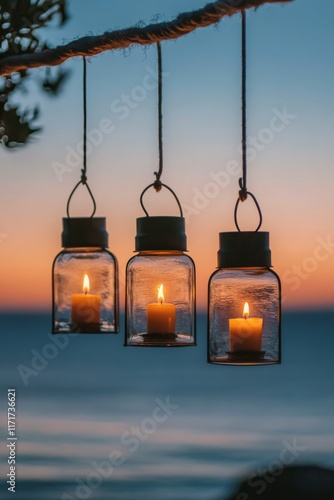 Beautiful lanterns with candles hang above the ocean during sunset in a tranq...
