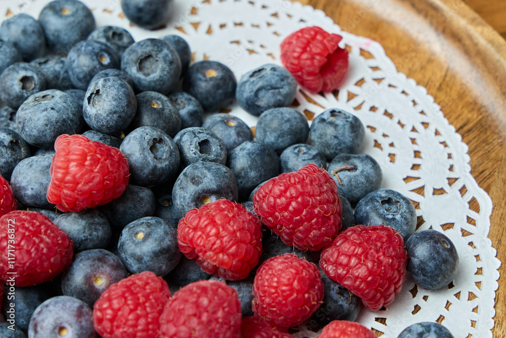 A Beautiful Serving of Fresh Blueberries and Raspberries Delightfully Arranged on a Decorative Plate A Beautiful Serving of Fresh Blueberries and Raspberries Delightfully Arranged on a Decorative Plate