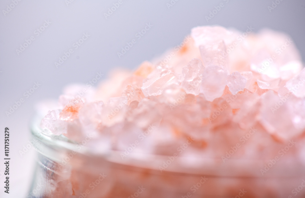 Fototapeta premium Himalayan salt, pink Himalayan salt crystals close up. Pink coarse salt crystals macro shot, over pastel blue background