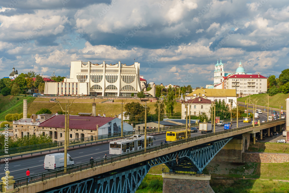Fototapeta premium Panoramic view of the city on a sunny summer day. A road bridge crosses the river in the city.