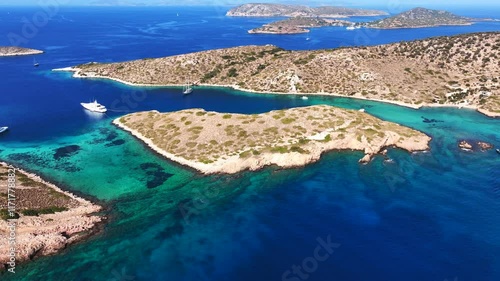 Aerial drone cinematic video of paradise blue lagoon and sandy beaches of Tiganakia bay forming a complex of small islets in island of Arkoi or Arki visited by yachts and sailboats, Dodecanese, Greece photo