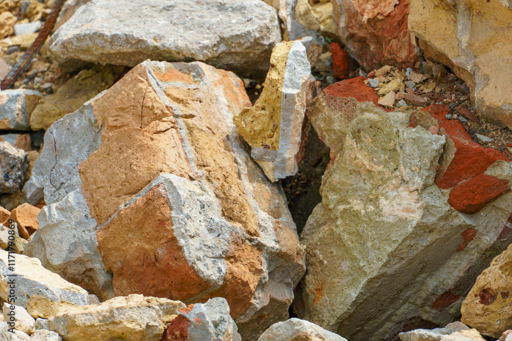 Naklejka premium Piles of broken old bricks and other construction debris at the construction site. Construction background.