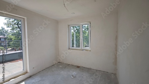 Room in the process of renovation, with window and access to the terrace, concrete tile on the floor and empty plastered walls